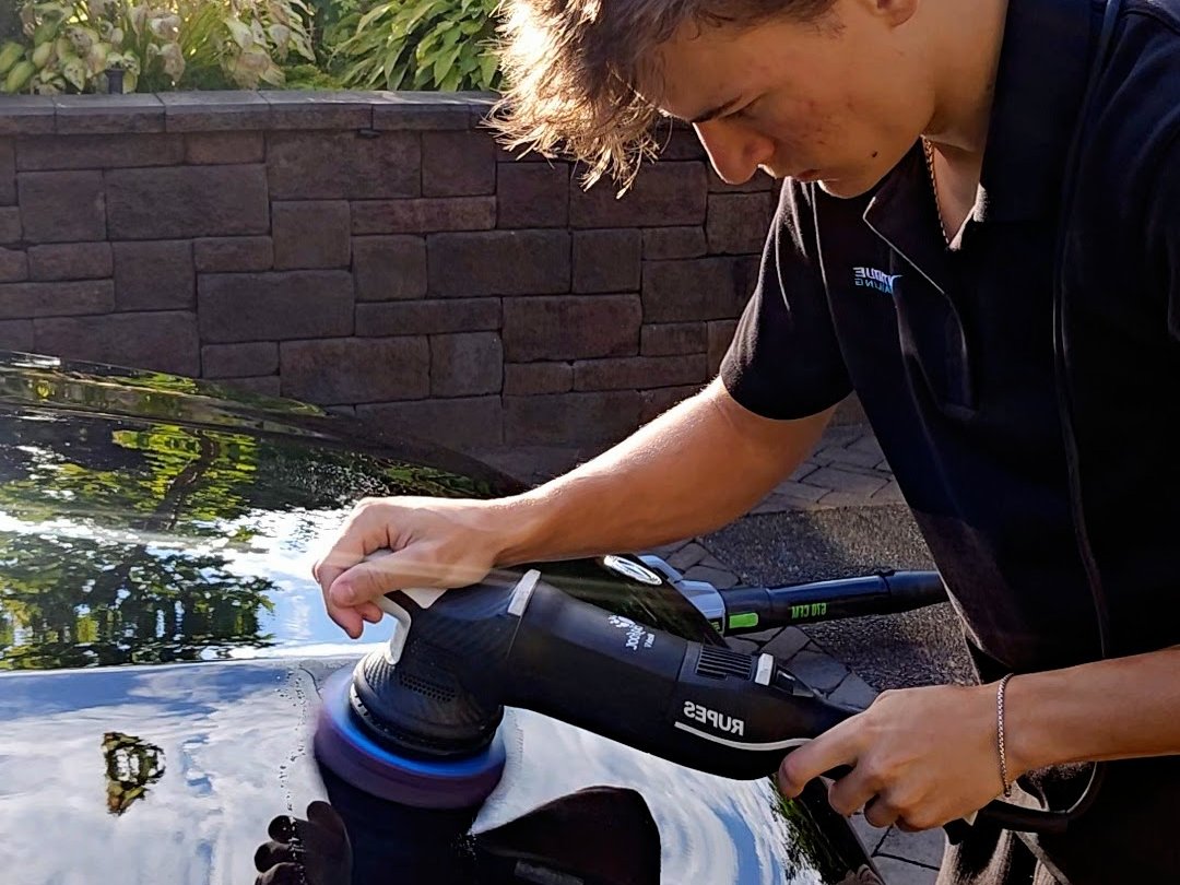 Vantique Detailing machine polishing the hood of a dark car during paint correction